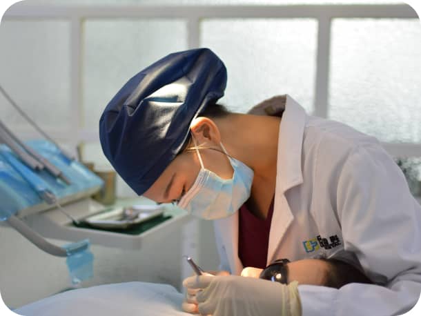 女性の歯科医が、口内を治療している様子１