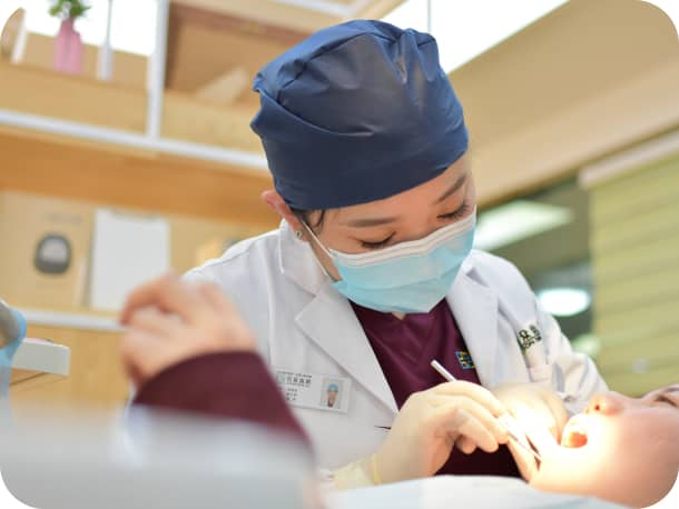 女性の歯科医が、口内を治療している様子２